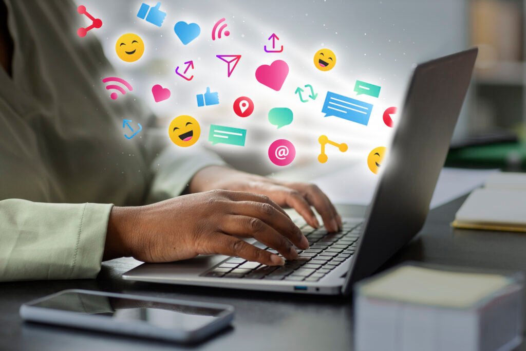 Uma pessoa usa o computador para definir estratégias de marketing digital para políticos. Símbolos que remetem às redes sociais saem da tela.